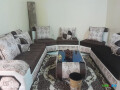 salon-marron-beige-avec-tapis-et-rideaux-peu-utilise-small-1